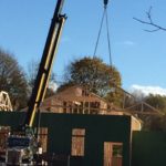 Crane placing roof trusses