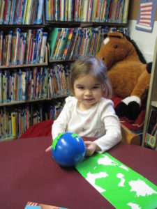 Young girl holding small globe