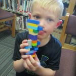 boy showing his lego vehicle