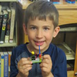 boy showing his lego vehicle