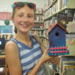Girl holding decorated bird house