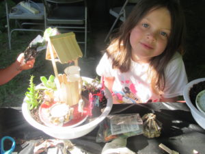 Girl with fairy garden she made.