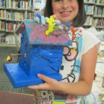 Girl holding decorated bird house