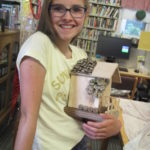 Girl holding decorated bird house